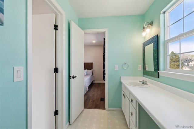 bathroom with vanity, baseboards, and connected bathroom