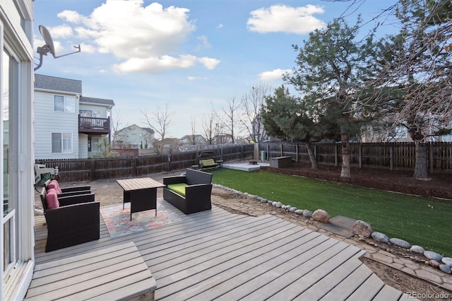 wooden terrace featuring a fenced backyard and a lawn