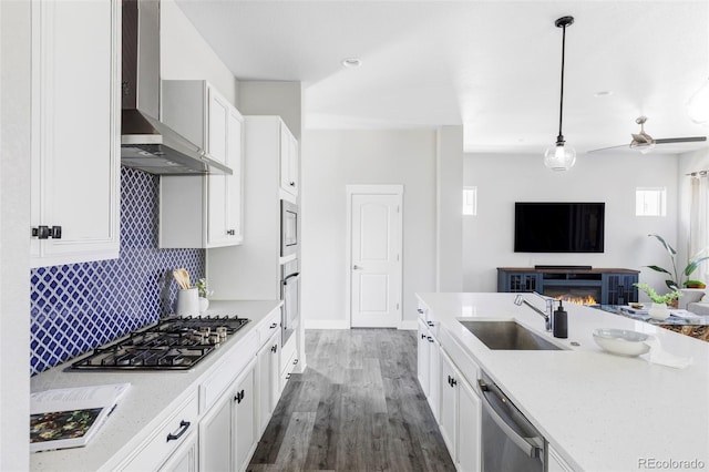 6037 N Netherland Ct, Aurora, CO 80019 - kitchen with wall chimney range hood, stainless steel appliances, a sink, open floor plan, and wood finished floors