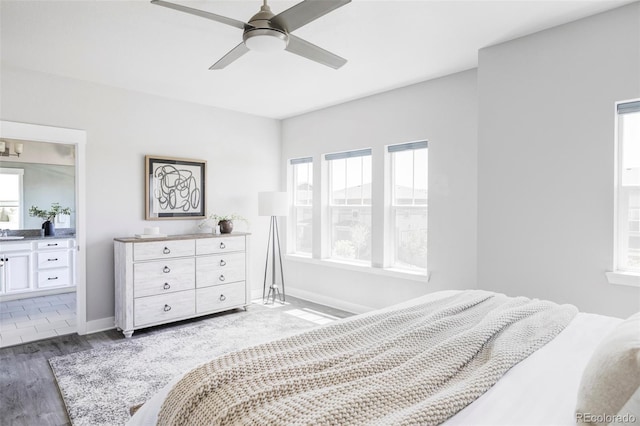 6037 N Netherland Ct, Aurora, CO 80019 - bedroom with wood finished floors, baseboards, connected bathroom, and a ceiling fan