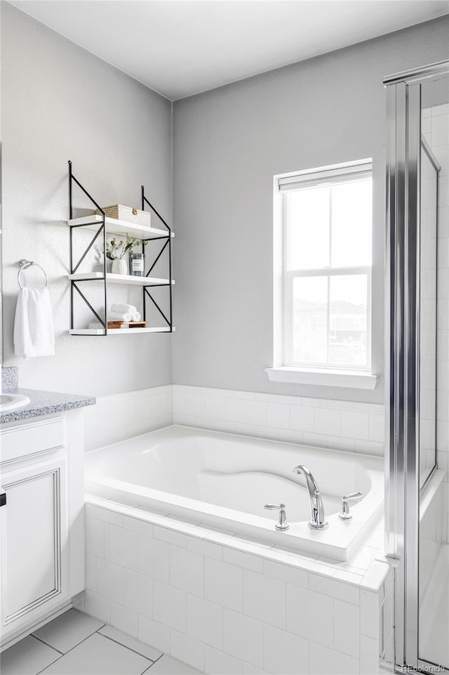 6037 N Netherland Ct, Aurora, CO 80019 - full bathroom featuring a garden tub, vanity, tile patterned floors, and a shower stall