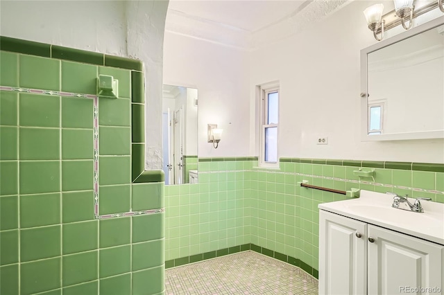 bathroom with vanity and tile walls