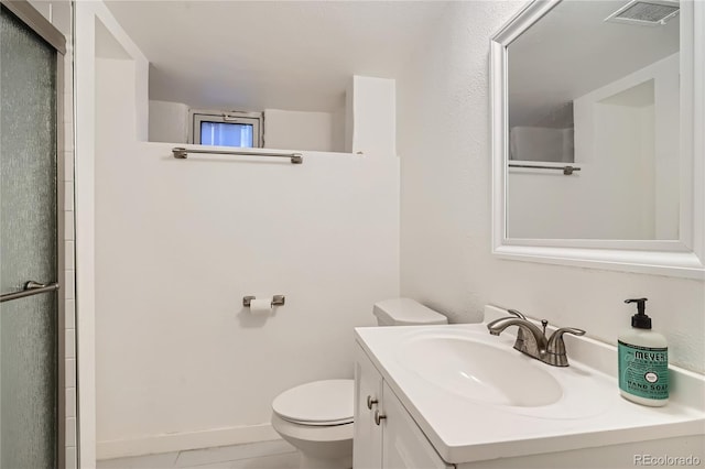 bathroom with tile patterned floors, vanity, an enclosed shower, and toilet