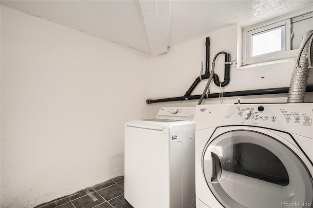 washroom with washing machine and dryer and dark tile patterned floors