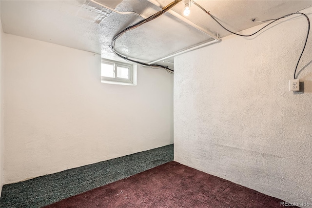 basement with dark carpet and a textured ceiling