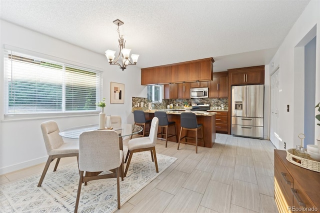 dining room featuring a textured ceiling and an inviting chandelier