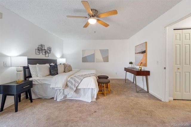 bedroom featuring ceiling fan, a textured ceiling, light carpet, and a closet