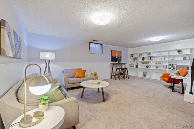 carpeted living room featuring built in shelves and a textured ceiling