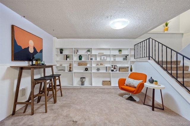 sitting room with a textured ceiling and light carpet