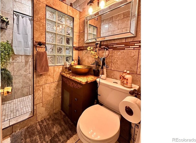 bathroom featuring toilet, a shower with shower curtain, and tile walls