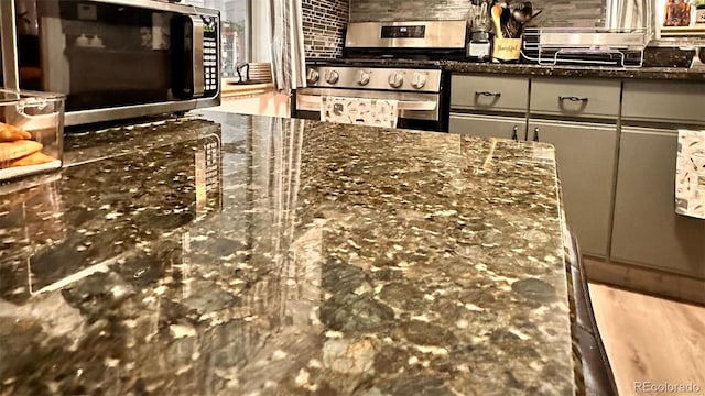 interior details featuring gray cabinets, stainless steel appliances, and dark stone counters