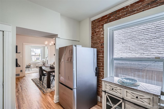 2564 N Emerson St, Denver, CO 80205 - kitchen with freestanding refrigerator, brick wall, light wood-style flooring, light stone countertops, and a chandelier