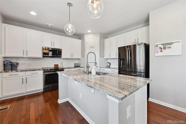 76 N Ider St, Aurora, CO 80018 - kitchen with appliances with stainless steel finishes, tasteful backsplash, white cabinetry, dark wood-style flooring, and recessed lighting