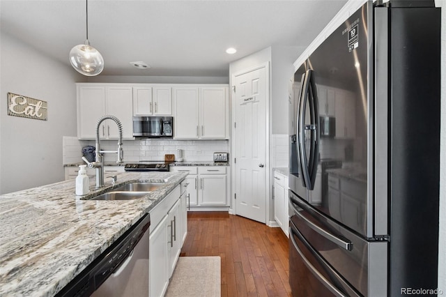 76 N Ider St, Aurora, CO 80018 - kitchen featuring appliances with stainless steel finishes, white cabinets, pendant lighting, dark wood-style floors, and light stone countertops