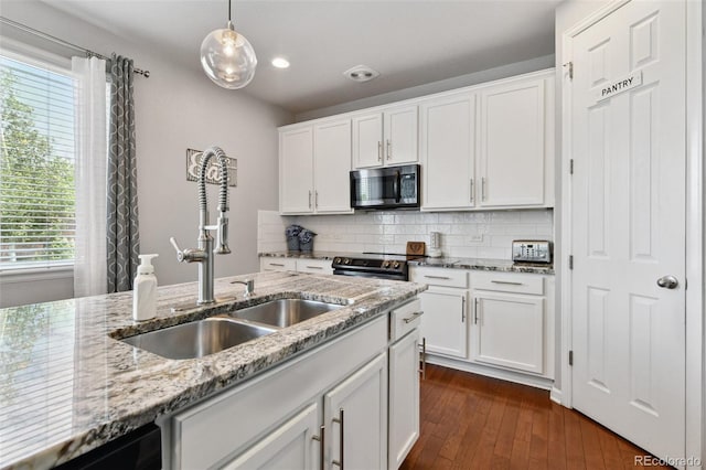76 N Ider St, Aurora, CO 80018 - kitchen with stainless steel microwave, electric range oven, backsplash, white cabinetry, and dark wood-type flooring