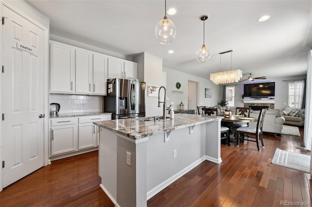 76 N Ider St, Aurora, CO 80018 - kitchen with stainless steel fridge with ice dispenser, dark wood finished floors, open floor plan, white cabinets, and recessed lighting