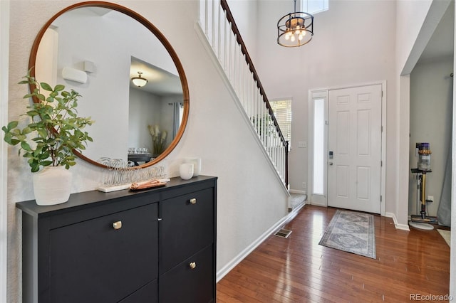 76 N Ider St, Aurora, CO 80018 - entryway featuring wood-type flooring, stairway, healthy amount of natural light, a chandelier, and a towering ceiling