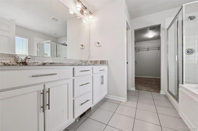 76 N Ider St, Aurora, CO 80018 - bathroom with double vanity, a stall shower, tile patterned flooring, and a walk in closet