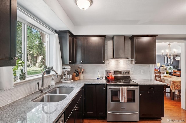 13140 W 15th Dr, Golden, CO 80401 - kitchen with stainless steel range with electric stovetop, wall chimney range hood, light stone counters, and decorative backsplash