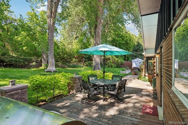 13140 W 15th Dr, Golden, CO 80401 - wooden terrace featuring a storage shed, outdoor dining area, a yard, and view of scattered trees