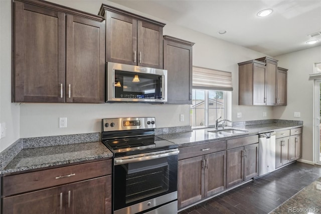 kitchen featuring dark brown cabinetry, stainless steel appliances, dark wood-type flooring, and sink