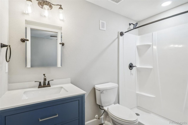 bathroom with walk in shower, vanity, and toilet