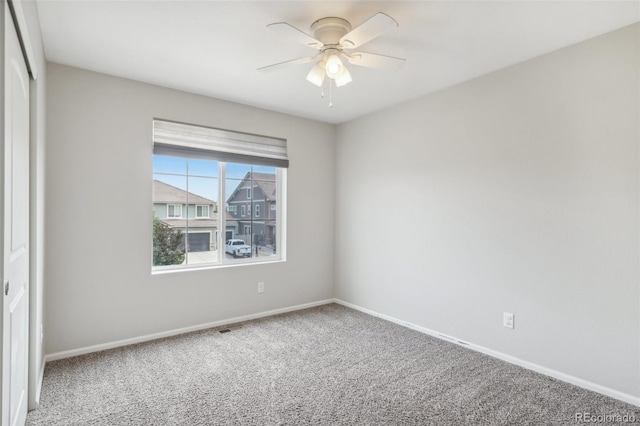 carpeted spare room featuring ceiling fan