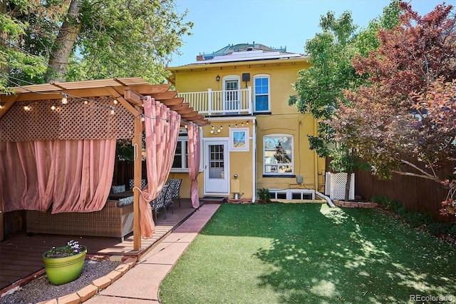 back of property featuring a pergola and solar panels