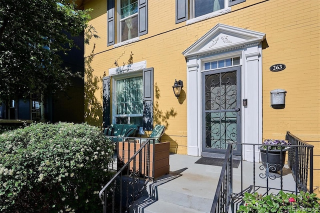 doorway to property featuring brick siding
