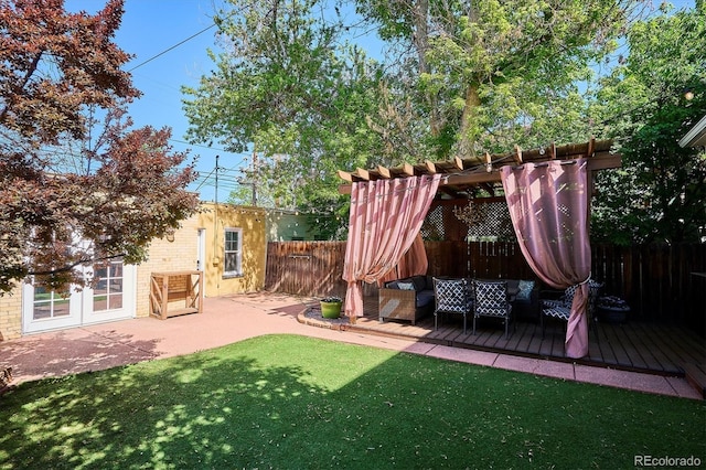 view of yard featuring a wooden deck, an outdoor living space, a pergola, and a patio area