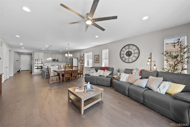 3575 White Rose Loop, Castle Rock, CO 80108 - living area with a ceiling fan, healthy amount of natural light, recessed lighting, wood finished floors, and a chandelier