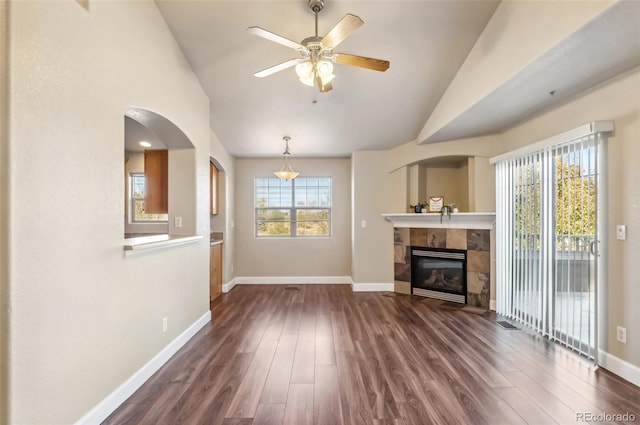 unfurnished living room featuring lofted ceiling, dark wood-type flooring, and a healthy amount of sunlight