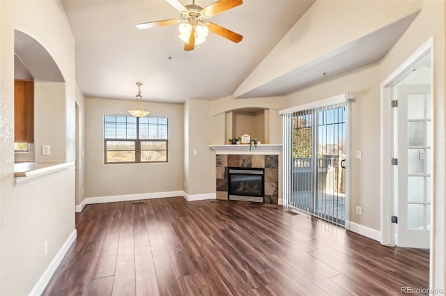 unfurnished living room with a healthy amount of sunlight, lofted ceiling, and dark wood-type flooring