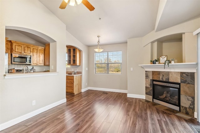 living room with a fireplace, ceiling fan, and dark hardwood / wood-style flooring