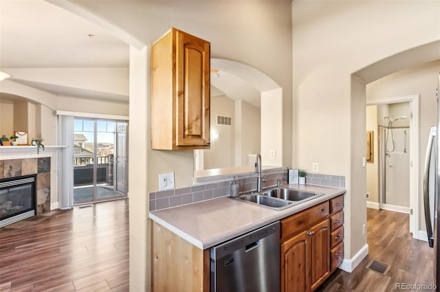 kitchen with dark wood-type flooring, sink, stainless steel dishwasher, and vaulted ceiling