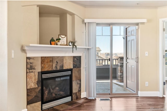 living room featuring a tile fireplace and dark hardwood / wood-style flooring