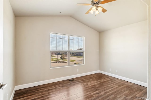 spare room with dark hardwood / wood-style flooring, vaulted ceiling, and ceiling fan