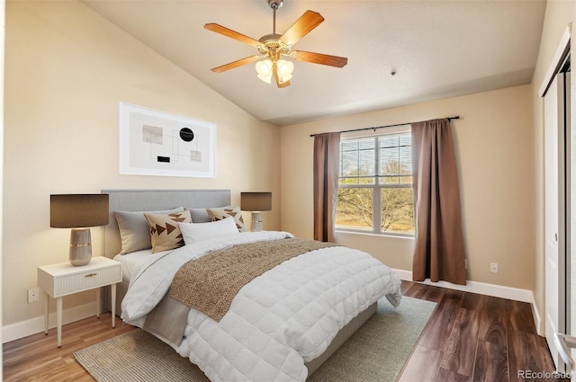 bedroom with a closet, hardwood / wood-style flooring, ceiling fan, and lofted ceiling