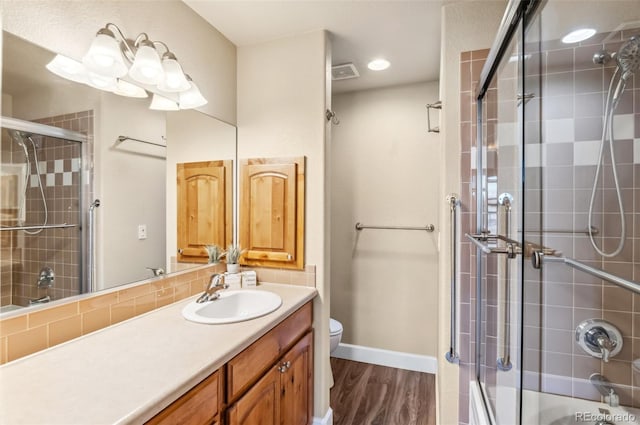 bathroom with wood-type flooring, vanity, toilet, and walk in shower