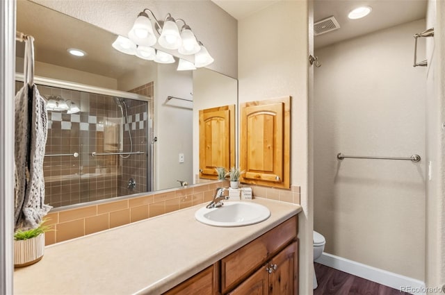 bathroom featuring a shower with shower door, toilet, wood-type flooring, and vanity