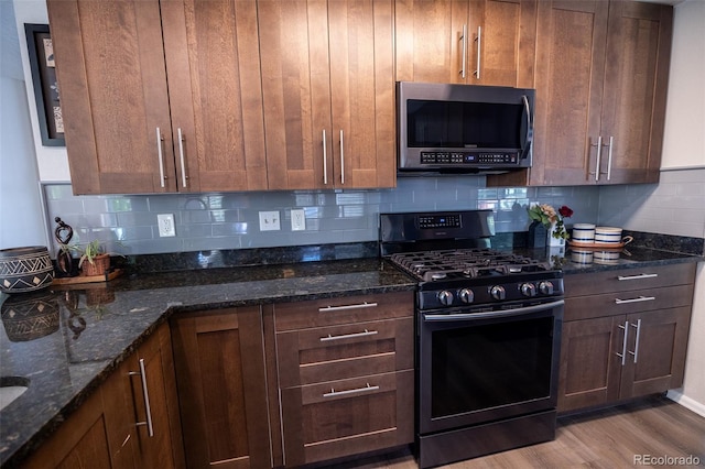 5630 W 115th Ave, Westminster, CO 80020 - kitchen with stainless steel microwave, black range with gas cooktop, decorative backsplash, and dark stone countertops