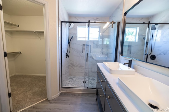 5630 W 115th Ave, Westminster, CO 80020 - full bathroom featuring a marble finish shower, double vanity, a spacious closet, and wood finished floors