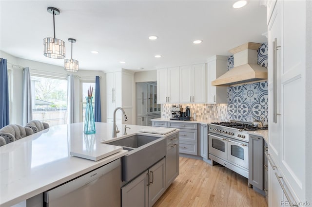 kitchen with dishwashing machine, premium range hood, a sink, backsplash, and double oven range