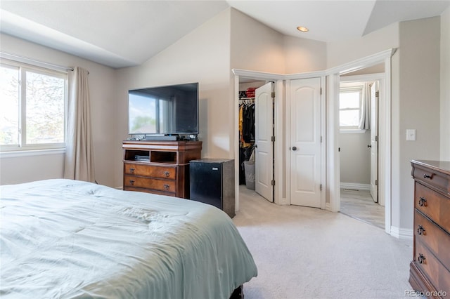 bedroom featuring a closet, baseboards, vaulted ceiling, and light colored carpet