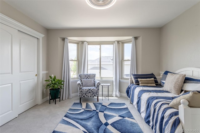 bedroom featuring baseboards and light colored carpet