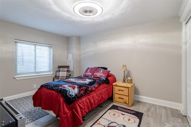 bedroom with baseboards and wood finished floors