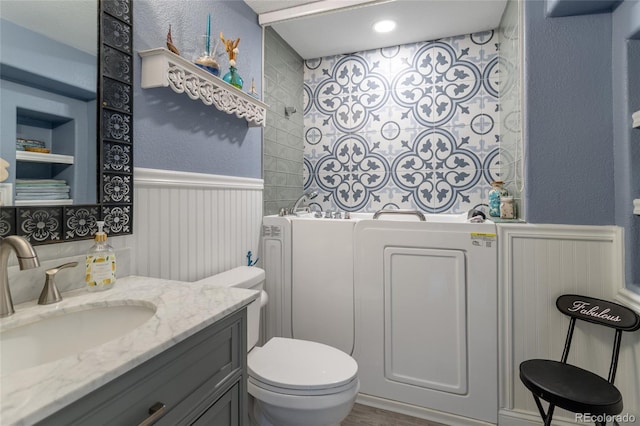 bathroom featuring vanity, wainscoting, toilet, and wood finished floors