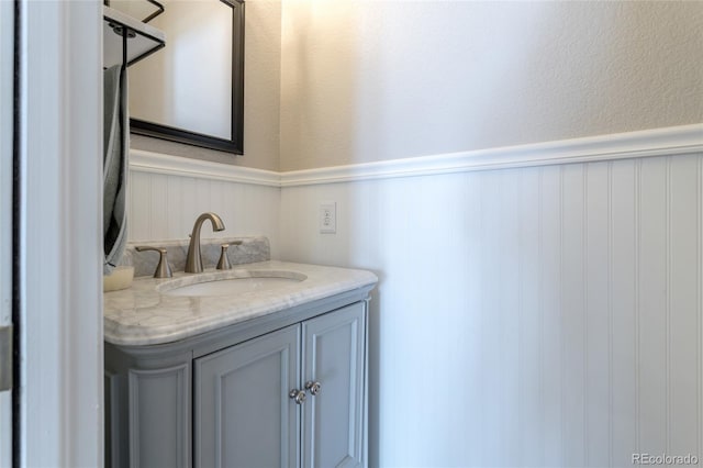bathroom featuring vanity and a wainscoted wall