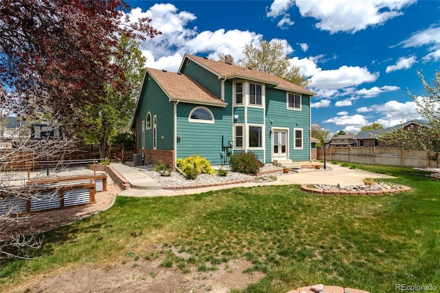 rear view of property featuring a lawn, a patio area, fence, and entry steps