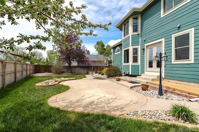 view of yard featuring entry steps, a fenced backyard, and a patio area